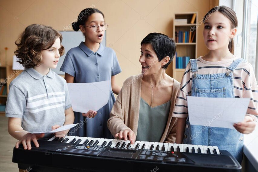 学校の教室でピアノの前に集まる子どもたち